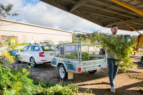 This is a photograph of a man emptying green waste from a trailer at Nillumbik Shire Council's Recycling Centre.