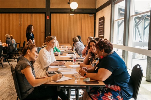 A group of business owners networking seated at a table in the Eltham Community and Reception Centre