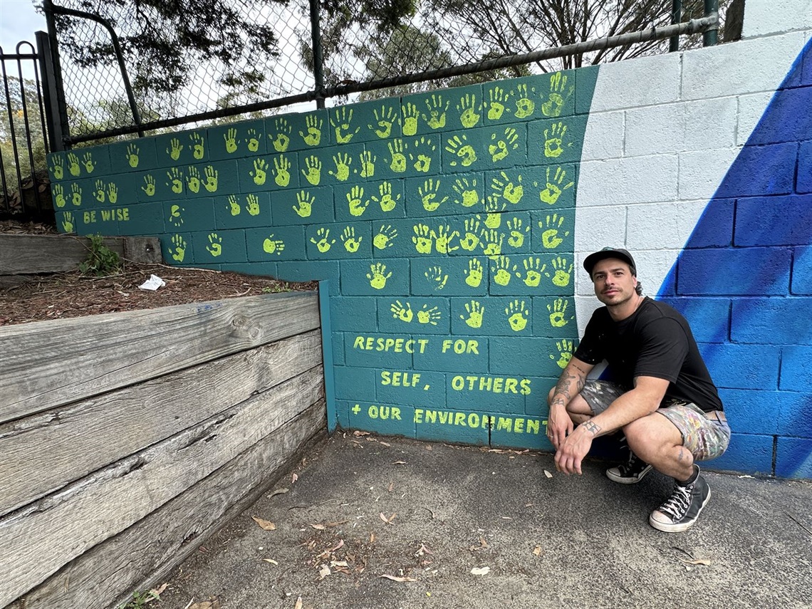 Artist Paink with a student-assisted mural at Our Lady Help of Christians school in Eltham with a 16 Days grant in 2025.