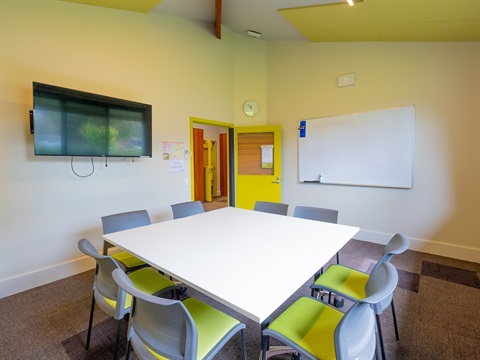 A room with a table surrounded by eight chairs