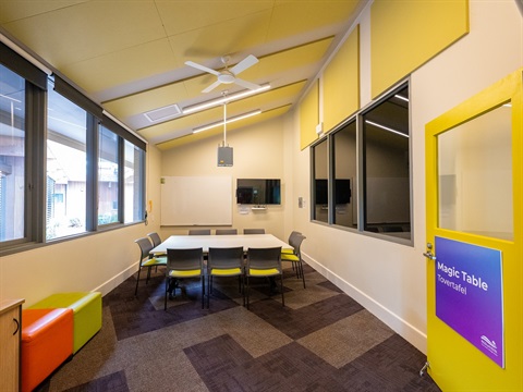 Large room with sloping ceiling and windows along the walls