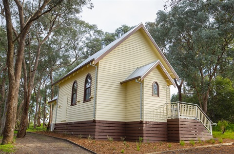 Photo of a wooden church surrounded by trees