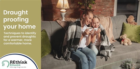 This is an image of two people sitting on a couch with blankets