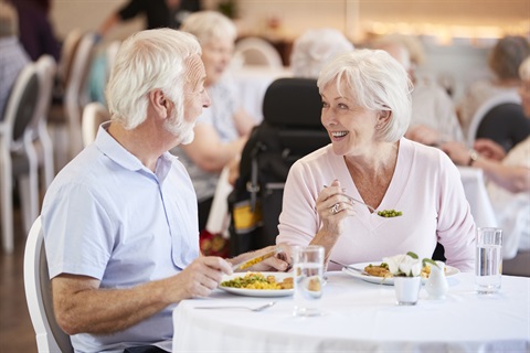 Two older people are eating at a restaurant