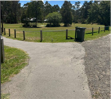 A wide gravelled path in front of a large grassed area