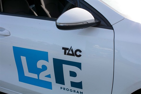 This is a close-up photograph of the side panel of an L2P car showing the L2P logo,