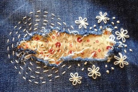 Embroidery around a whole in a pair of jeans