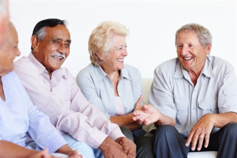 A group of older adults are smiling and in conversation